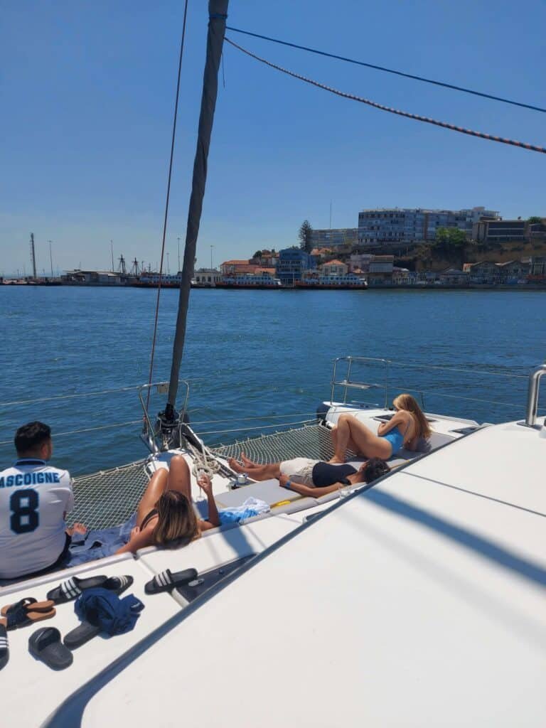 Pessoas a relaxar deitadas na rede do catamaran