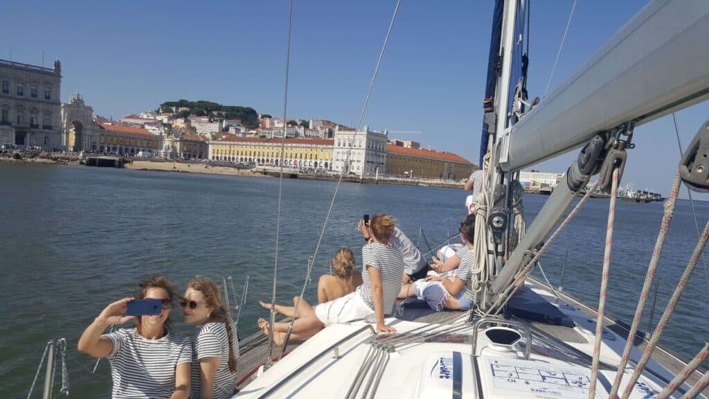 Pessoas num veleiro a contemplar a Praça do Comércio