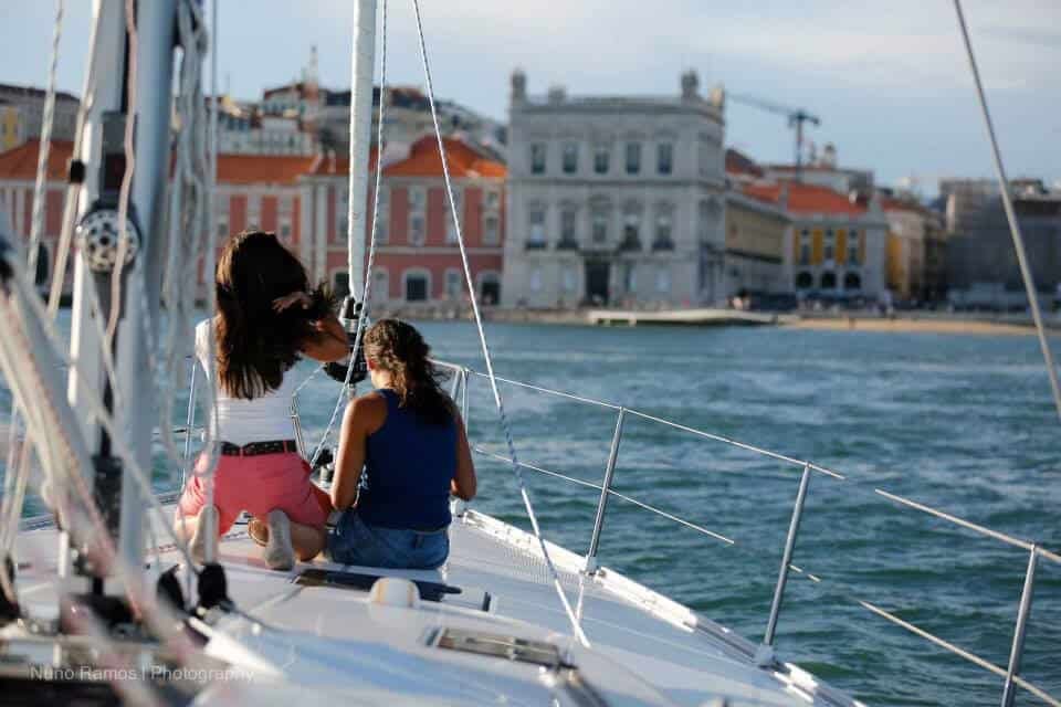 Duas mulheres num veleiro a contemplar a Praça do Comércio