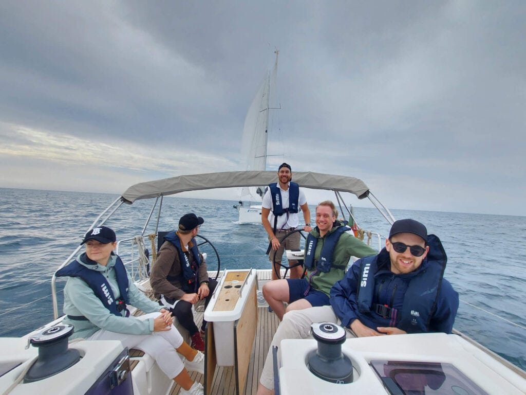 Eventos Team Building. Pessoas a tripular um veleiro durante uma regata em Cascais