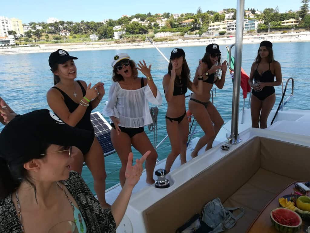 Jovens a cantar e a dançar num catamaran