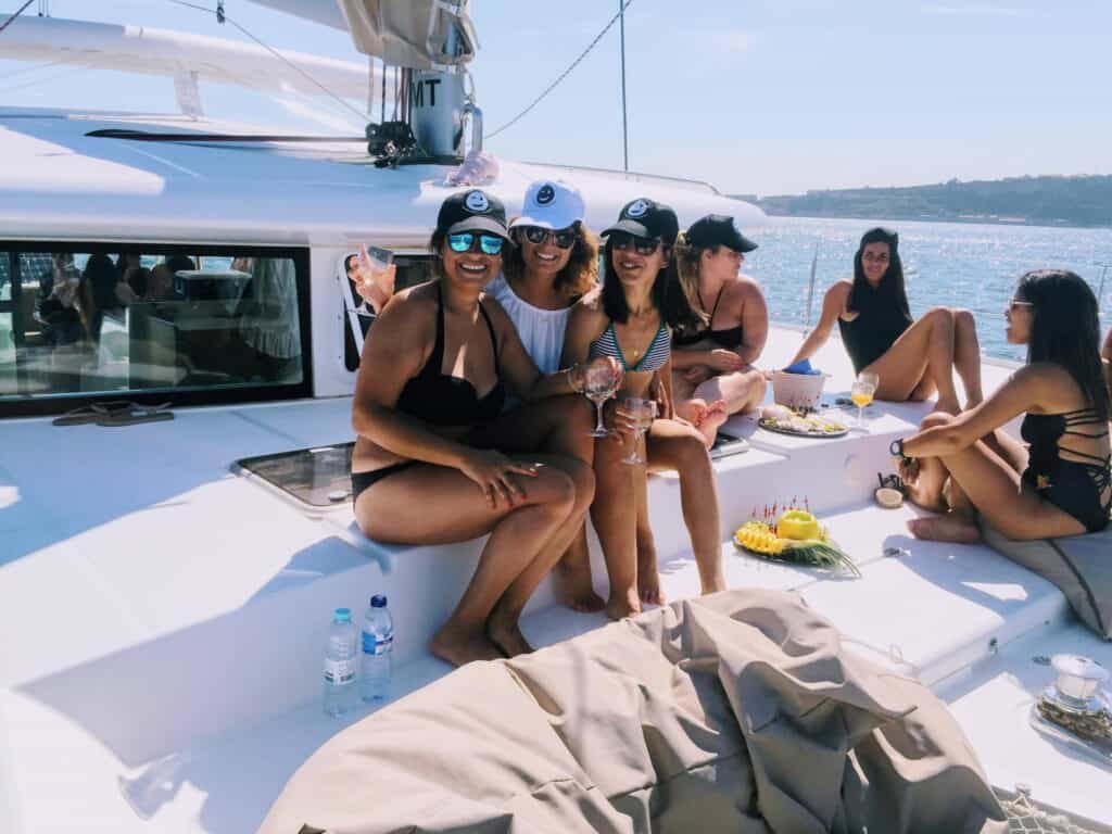 Jovens a divertirem-se na proa do catamaran