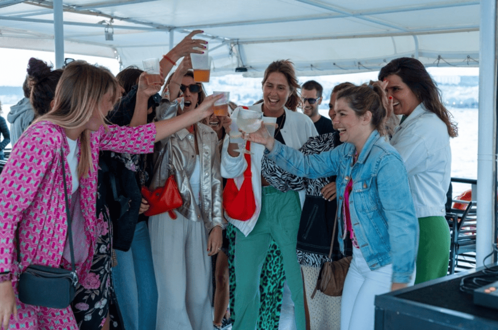 Amigas a celebrarem durante um passeio de barco no rio Tejo