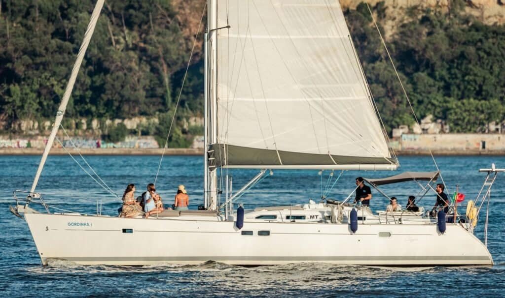 A foto é uma bela imagem de um barco à vela navegando em um mar calmo. Ela é uma representação relaxante e pacífica da natureza.