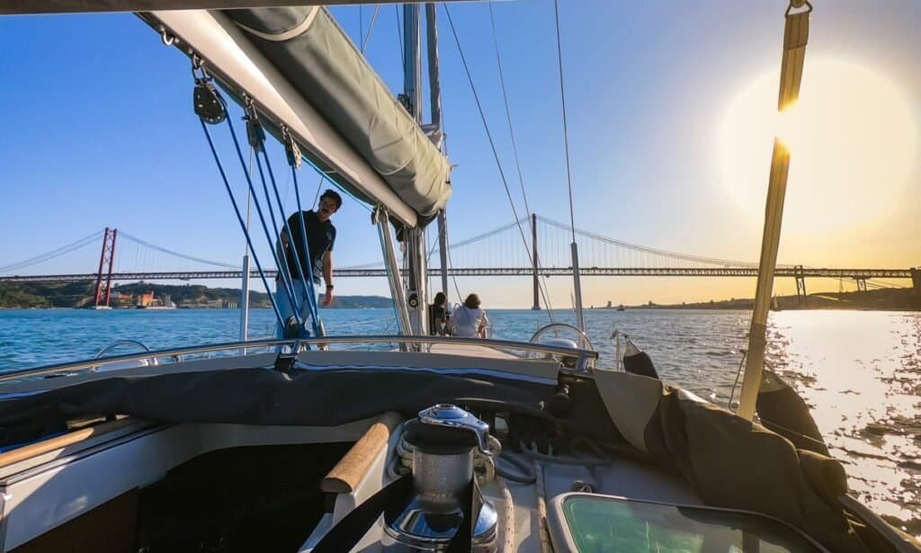 Um casal passeando de veleiro no rio Tejo, durante um dia maravilhoso em Lisboa